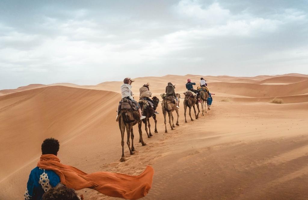 Menschen auf einem Kamelritt durch die Wüste