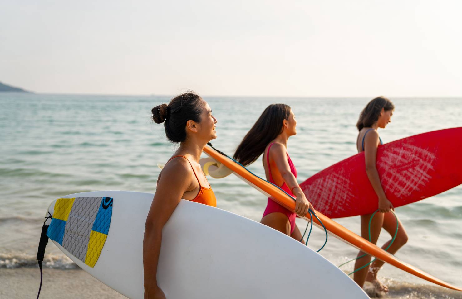 female friends surf on the beach