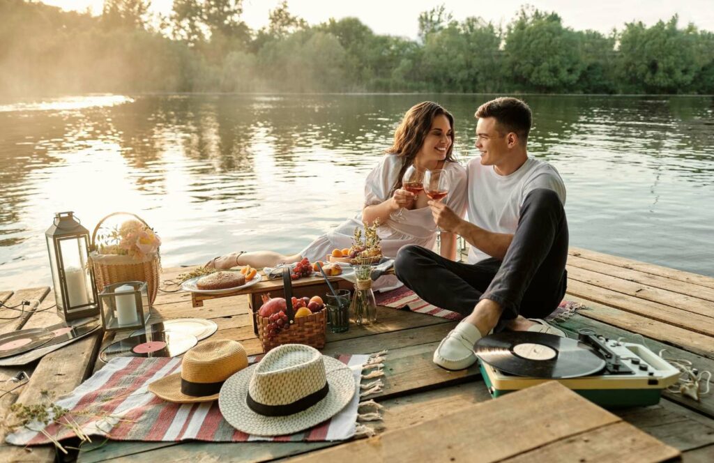 Een stel dat aan het picknicken is op een steiger aan het water