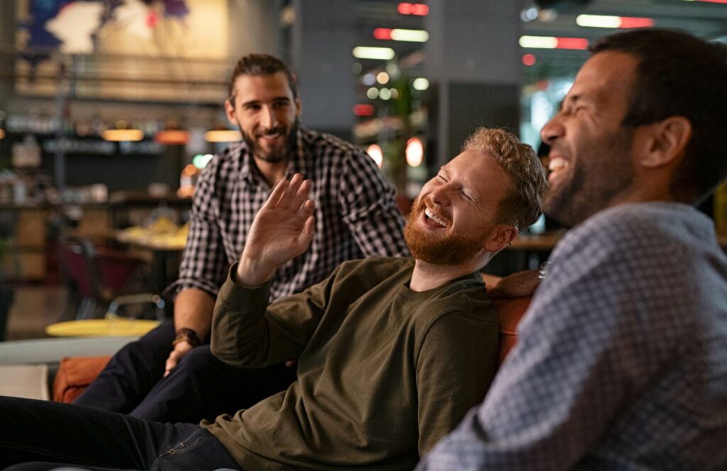 Männer lachen gemeinsam in einer Bar