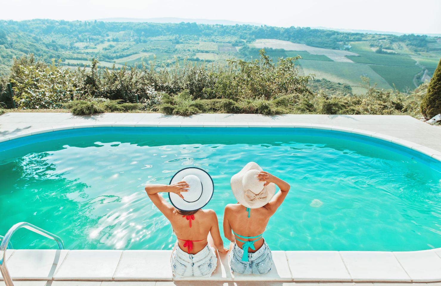 two friends enjoying a swimming pool in summer