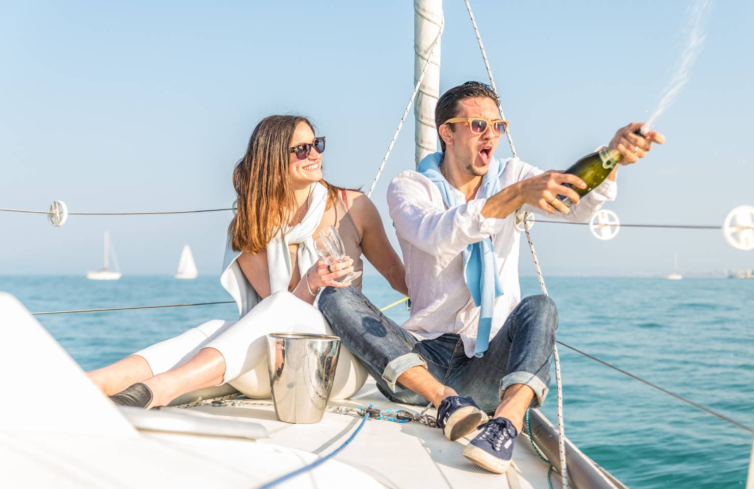 Un homme et une femme sur un bateau avec du champagne