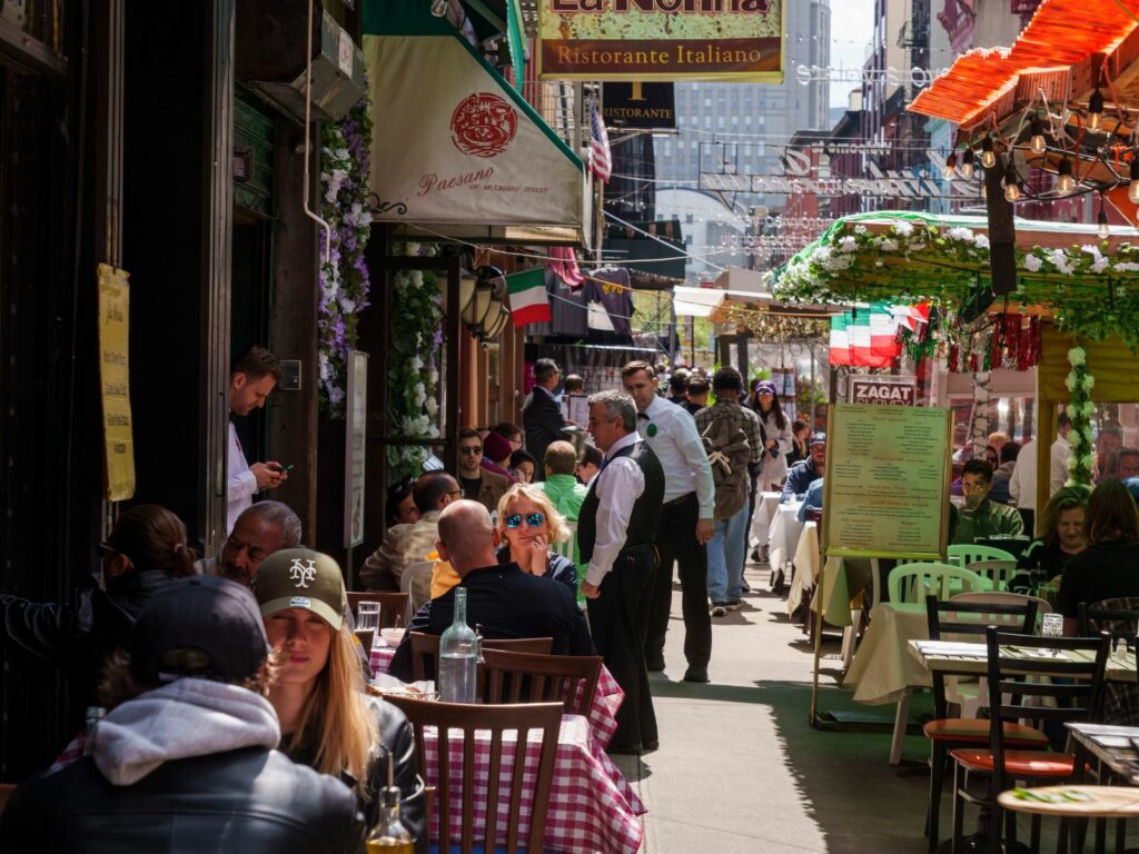 people eating outside in little italy new york - one of the best new york activities for friends