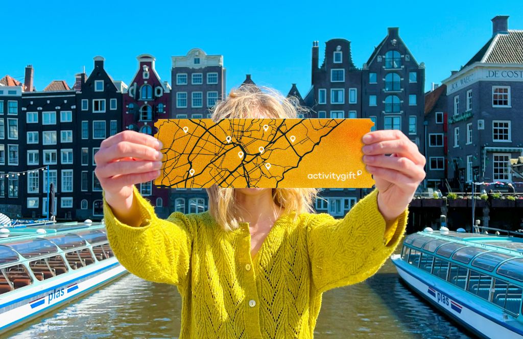 A woman holds an activity voucher on dam square in amsterdam