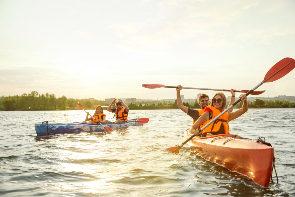 Freunde fahren mit Kanus auf einem See und erleben unvergessliche Sommeraktivitäten