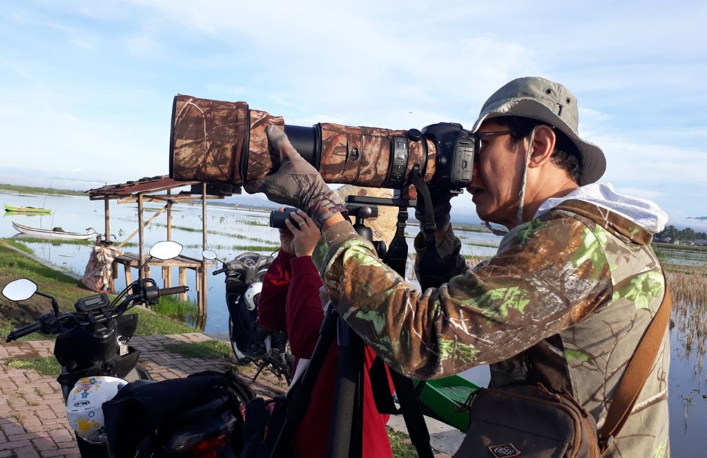 Man spotting birds with big binoculars