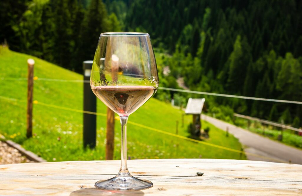 verre à vin sur une table avec une pelouse en arrière-plan