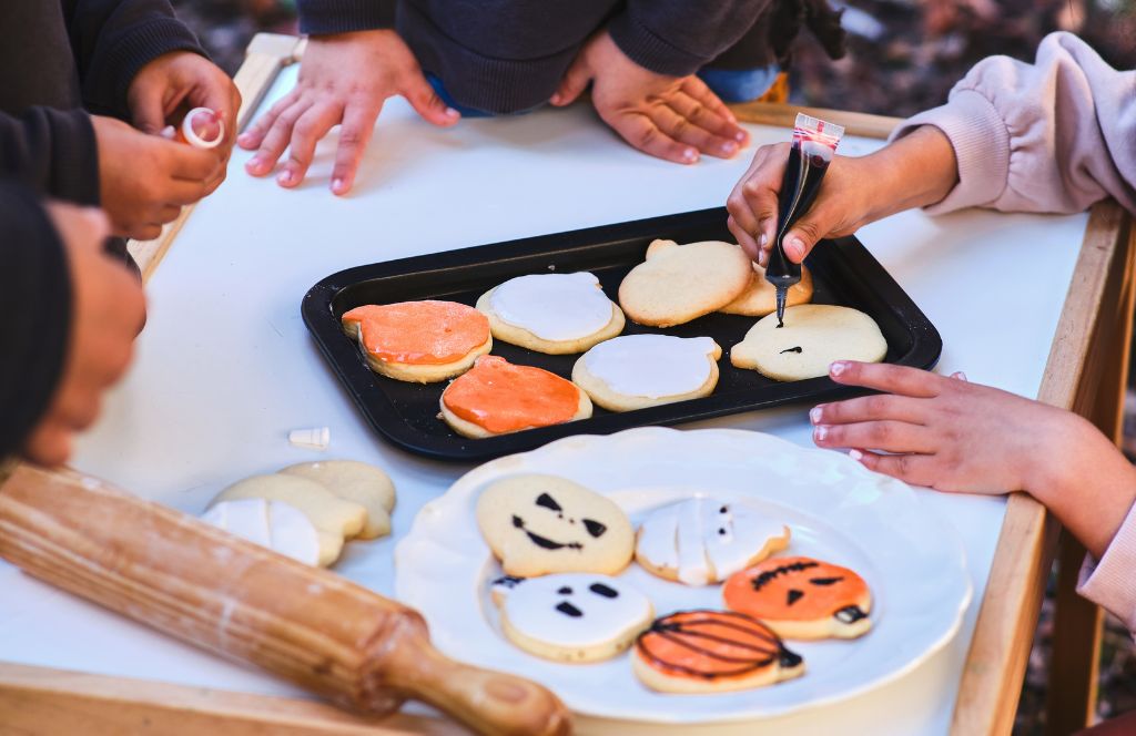 Kinder backen Kekse als lustige Halloween-Aktivität für Kinder