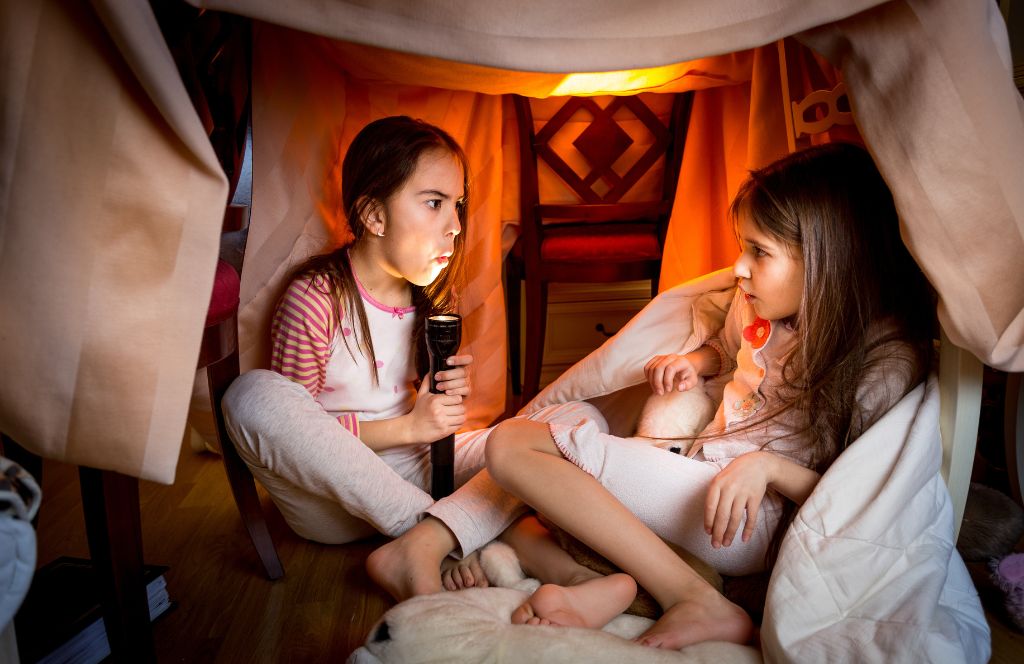 twee meisjes vertellen spookverhalen als leuke halloweenactiviteit