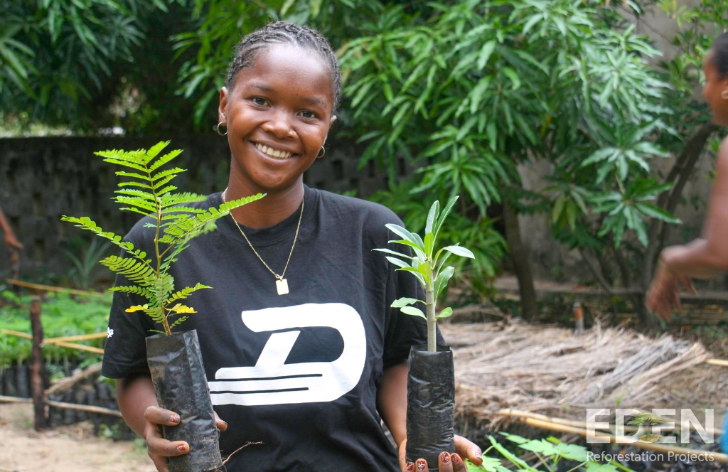 a girl smiles while planting trees thanks to the eden reforestation and activitygift collaboration