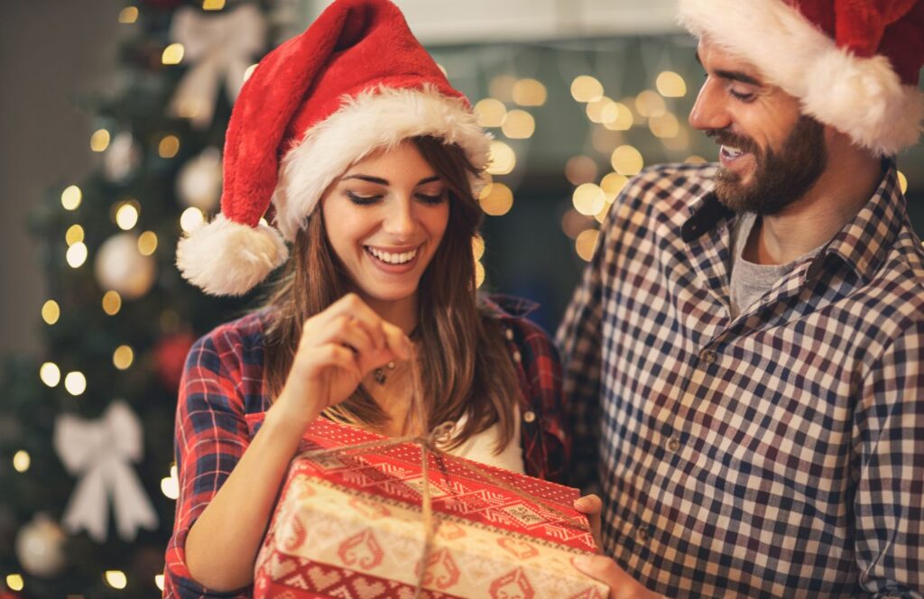 une femme surprise à l'ouverture des cadeaux lors d'un jeu pour ouvrir les cadeaux de Noël