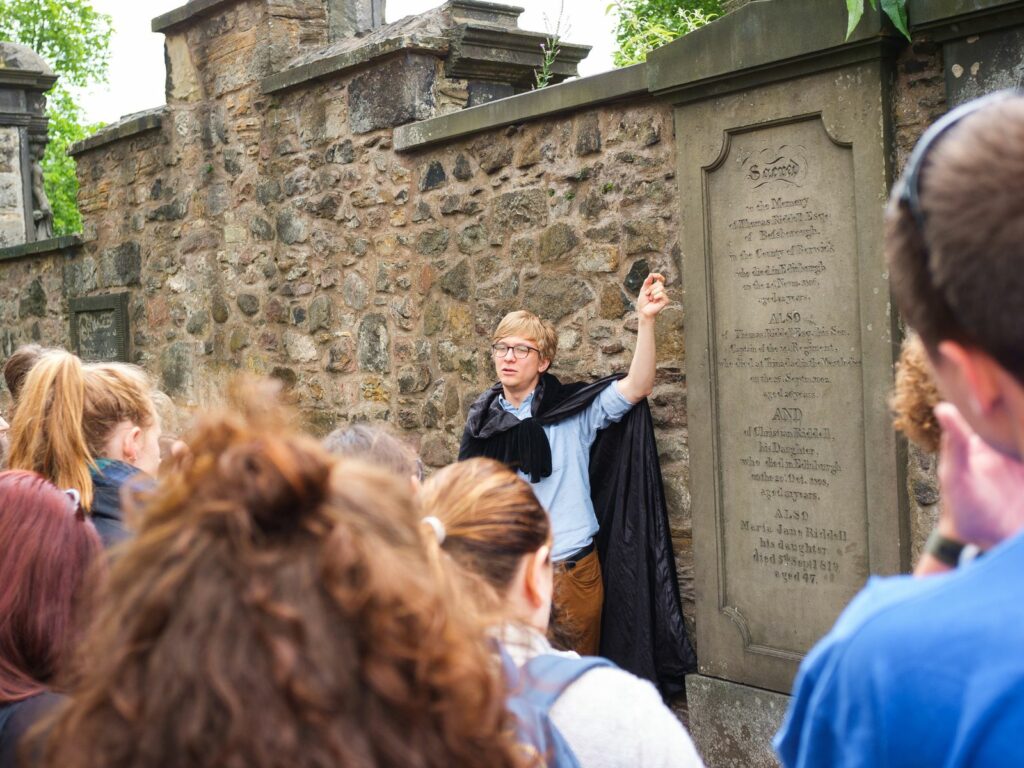 a man leads the greyfriars graveyard tour in edinburgh - a gift experience in scotland