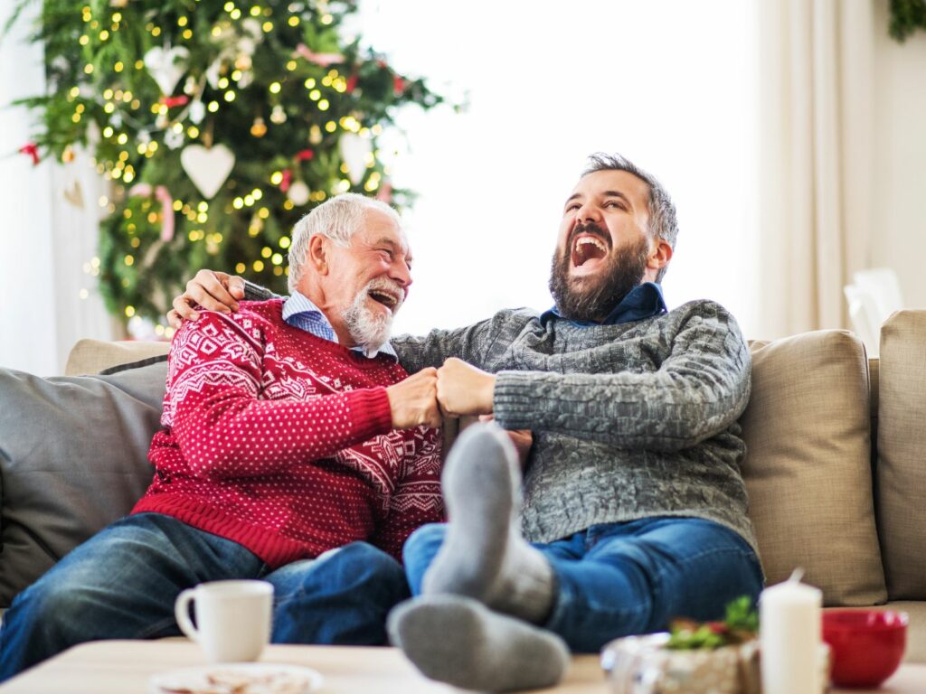 Männer schenken und lachen an Weihnachten