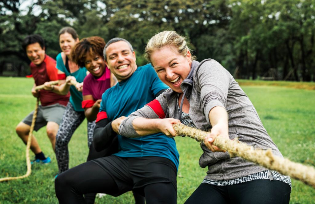 an office team plays tug of war as one of the best corporate team building activites