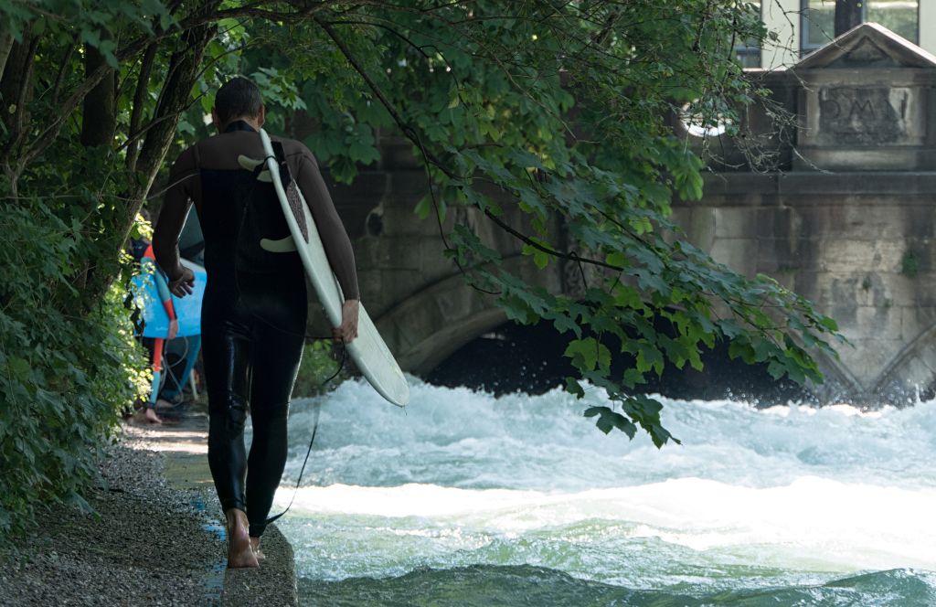 surfen in der Eisbachwelle als eines der besten Dinge, die man mit Freunden in München machen kann
