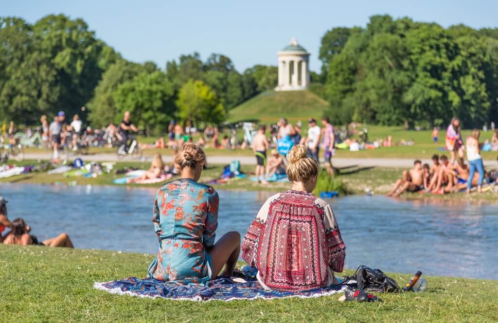 Zwei Freundinnen sitzen im Englischen Garten